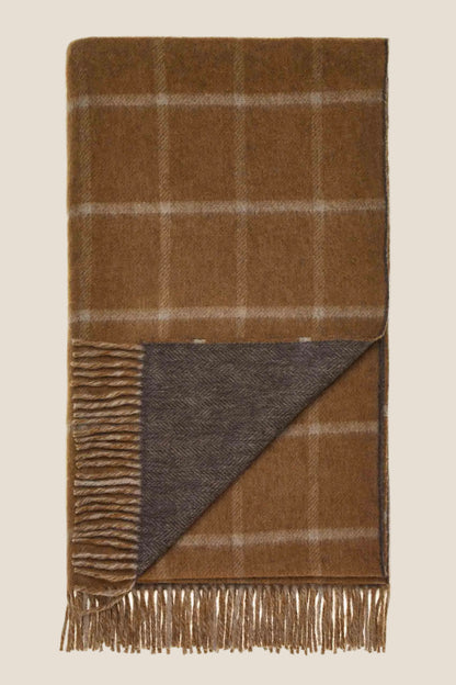 Brown plaid blanket with fringes on a white background